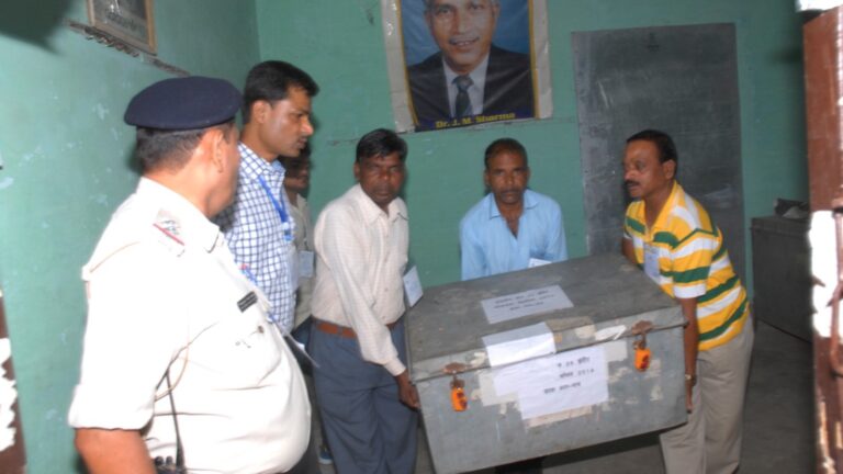 ఓట్ల లెక్కింపు కేంద్రంలో బ్యాలెట్ పెట్టె తరలిస్తున్న ఎన్నికల సిబ్బంది
