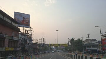 గువాహటి నగరంలో దుకాణాలు, వాహనాలతో ఉన్న రోడ్డు