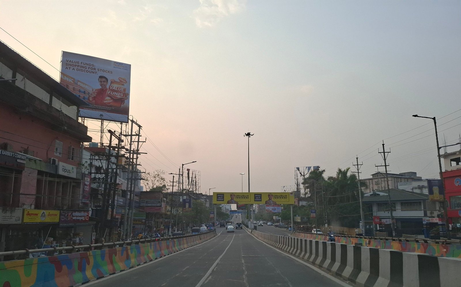 గువాహటి నగరంలో దుకాణాలు, వాహనాలతో ఉన్న రోడ్డు