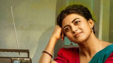ఎరుపు జాకెట్టు, ఆకుపచ్చ చీరలో పాత రేడియో పక్కన చెంపకు చేయి ఆన్చి నవ్వుతున్న ఆనంది.